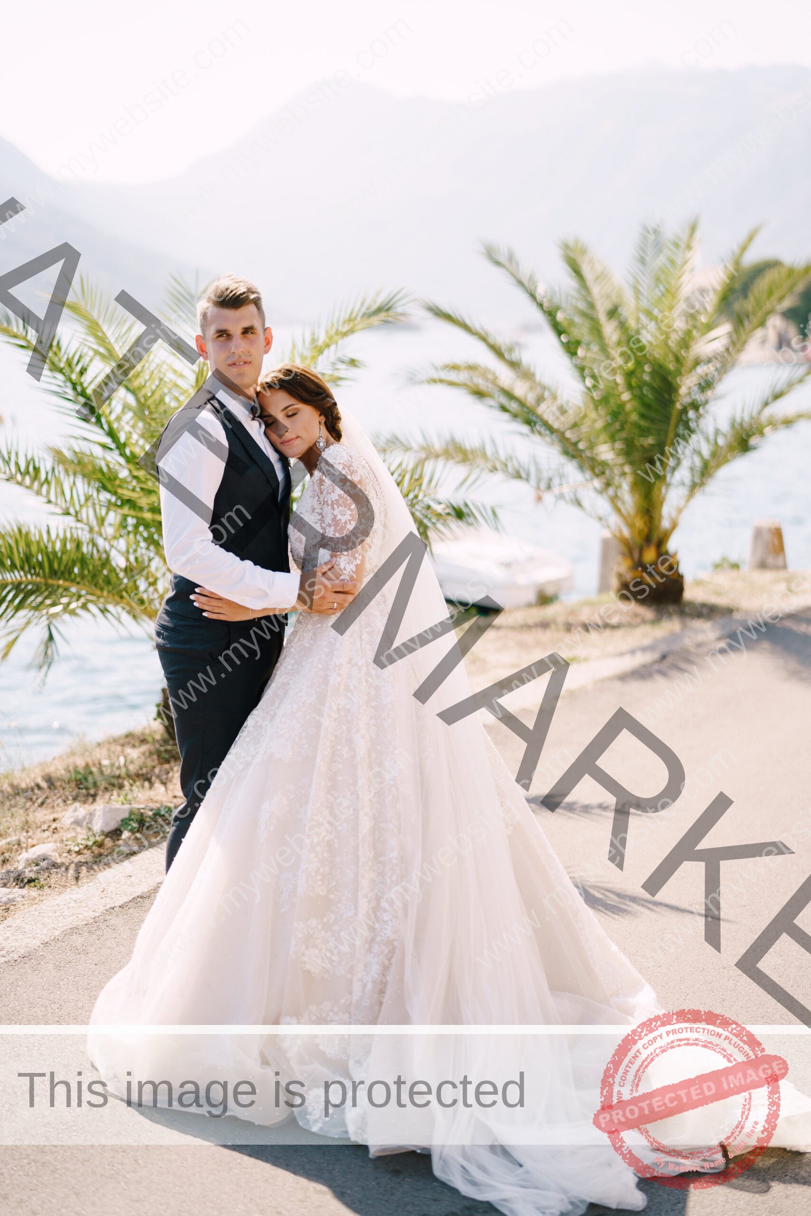 Wedding couple walks along the embankment near the sea, against the backdrop of palm trees, mountains and the old city. Fine-art wedding photo in Montenegro, Perast.