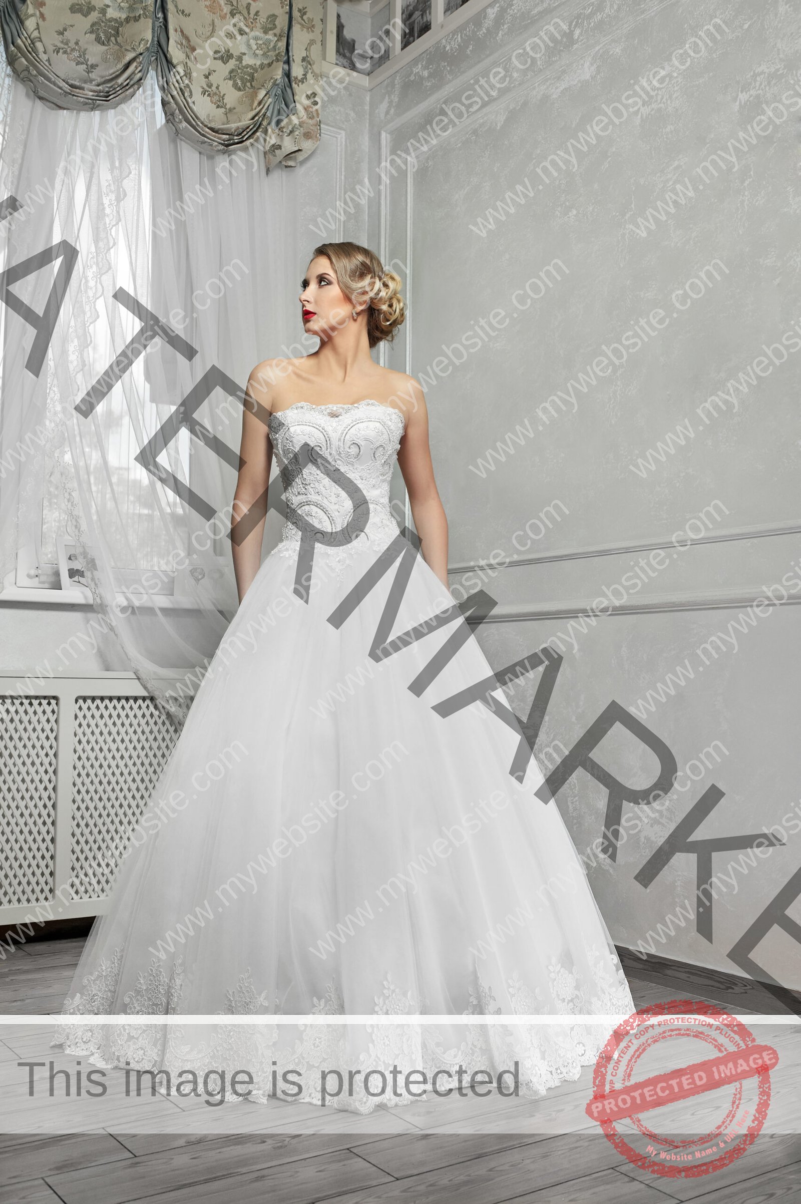 Young beautiful bride, woman in long white wedding dress on white background, hands on hips.